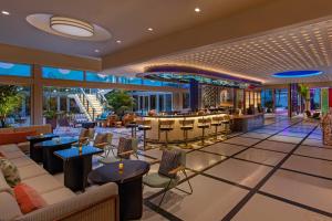 迈阿密海滩Moxy Miami South Beach的酒店大堂设有桌椅和酒吧