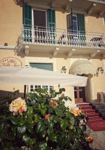 阿拉西奥利嘉别墅酒店的大楼前的白色雨伞和植物