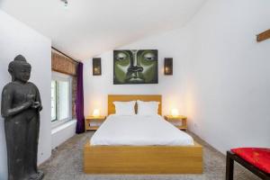 里斯本Kuta Loft Alfama的一间卧室配有一张床和雕像