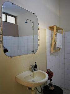 科托努提查尼俱乐部住宿加早餐旅馆的一间带水槽和镜子的浴室