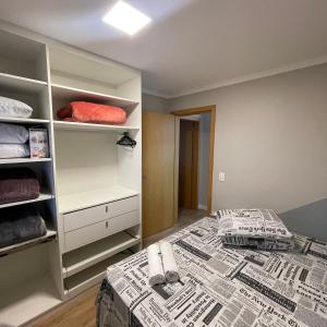 本图贡萨尔维斯Apartamento Elegante e aconchegante na Serra Gaúcha #的一间卧室设有一张床和一个书架