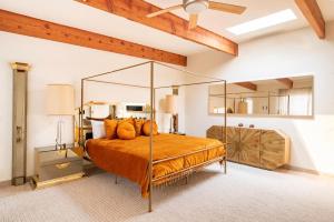 LandersPsychic Arches的一间卧室配有带橙色枕头的天蓬床