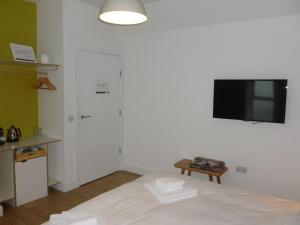 威克Portknockie - 1 Bed Room with Ensuite的卧室配有一张床和壁挂式平面电视。