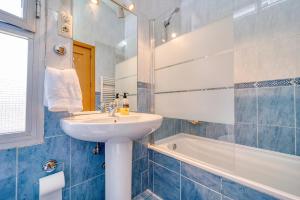 波苏埃洛-德阿拉尔孔CASACAFÉ Madrid Pozuelo Estación Private Rooms的蓝色和白色的浴室设有水槽和浴缸。