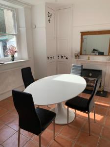 康威3 Newboro Terrace, Conwy的一间配备有白色桌椅的用餐室