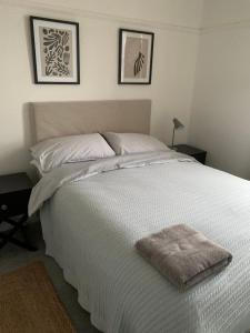 康威3 Newboro Terrace, Conwy的卧室内的一张白色床,墙上挂着两张照片