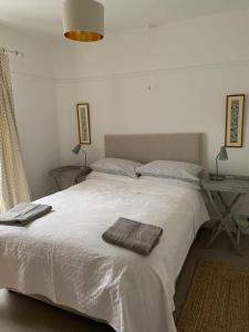 康威3 Newboro Terrace, Conwy的卧室配有白色的床和2条毛巾