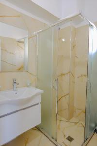 萨兰达Eleni Guest House的一间带玻璃淋浴和水槽的浴室