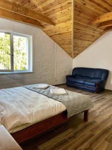 LisoveСадиба Бабина Лоза的一间卧室配有一张大床和一张蓝色的沙发