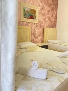 萨兰达Eleni Guest House的一间设有两张床铺和毛巾的房间