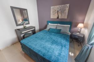 萨摩斯Sea Salt Village House的一间卧室配有蓝色的床和镜子