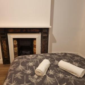 卢顿41 Crawley Road的一张带两条毛巾和壁炉的床