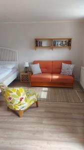 TadtenApartment Fritali的客厅配有橙色沙发和床。