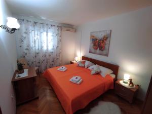 杜布罗夫尼克拉帕德马利亚公寓酒店的一间卧室配有橙色床和2条毛巾