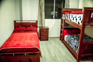JuiviCasa de Campo - Baños de Agua Santa的一间卧室配有两张双层床,铺有红色床单