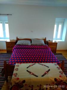 PolýdrosonCharlami's Mansion的一间卧室配有一张带红色和蓝色毯子的床