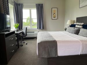 韦斯特切斯特Brinton Suites的一间卧室配有一张床、一张书桌和一台电视