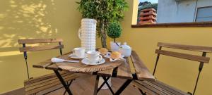 阿布鲁齐的罗塞托Dimora Mia的一张木桌,上面有杯子和碟子