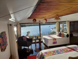 普诺Uros Lodge Perú的一间卧室配有一张床,享有船只的景色
