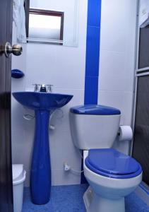 圣奥古斯丁Hotel Campestre El Triunfo的一间带卫生间和蓝色水槽的浴室