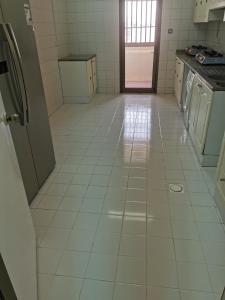 迪拜Cloud9 hostel的厨房铺有白色瓷砖地板,配有家电