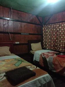 BajawaHome stay wolokoro ecotourism的木墙客房的两张床