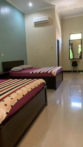 巴图卡拉Sederhana Homestay的带镜子的客房内设有两张床的房间