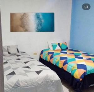 巴克里索莫雷诺港Casa de Alexis的卧室配有一张床,墙上挂有绘画作品