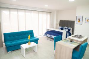 卡利Aparta suite tequendama的客厅配有蓝色的沙发和床。