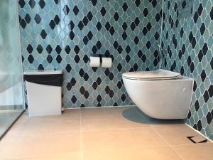 富国Phoenix Pool Villa Phu Quoc的一间带卫生间和瓷砖墙的浴室
