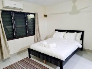 南迪Masters 2 Bedroom Apartment Westfield的一间卧室配有一张带白色床单的床和一扇窗户。