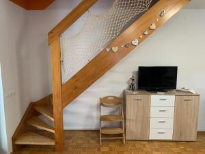 卡特兹奥布萨维Lotty的楼梯位于带书桌和电视的房间内