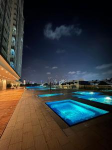 新山Paragon Residence 8-12pax-Big Balcony with BBQ的夜间蓝色海水游泳池