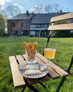 YébleronLe Manoir de la Campagne的一张带面包和一杯橙汁的野餐桌