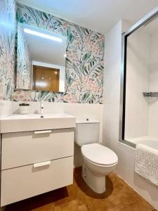 阿尔库迪亚Elena Playa Sol的一间带卫生间、水槽和镜子的浴室
