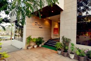 达博利Hotel Sadhana Executive的前面有盆栽植物的商店