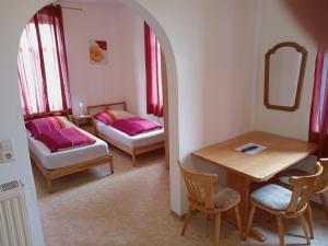 比兴博伊伦Hotel Kremer的客房设有桌子、床和桌椅。
