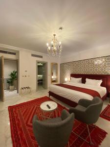 西迪·布·赛义德La Menara Hotel & SPA的一间卧室配有一张床、两把椅子和一个吊灯