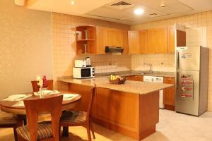 迪拜艾尔马纳尔公寓大酒店的厨房配有桌子和冰箱