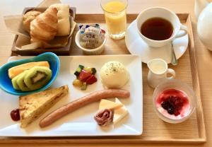 京都Kyoto Shijo Takakura Hotel Grandereverie的托盘,托盘上放着香肠和面包,还有一杯咖啡