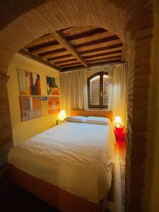 蒙特普齐亚诺The Small Sweet House的一间卧室配有一张带两盏灯的大型白色床。