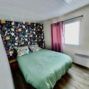 米米藏Mammiehome - 6 places - Mimizan - Camping La Lande的一间卧室设有一张带花墙的绿色床