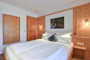 旧天鹅堡阿尔彭斯图本酒店的一间卧室配有一张白色大床和木柜