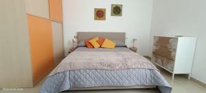 马泰拉Sweet holidays的一间卧室配有带两个橙色枕头的床