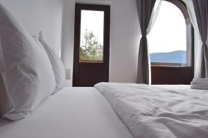 锡纳亚Cosy&Minimalistic Apartments - Haret Building的卧室配有白色的床和窗户