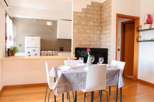 Castelnuovo di VeronaGarda residence Gardaland的一间带桌子和白色椅子的用餐室
