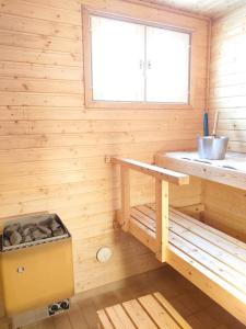 塔库沃里Rivitalon lomahuoneisto Tahkolla的小木屋设有长凳和窗户。