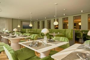于斯德阿特兰蒂克乔斯特酒店的一间带桌子和绿色椅子的餐厅