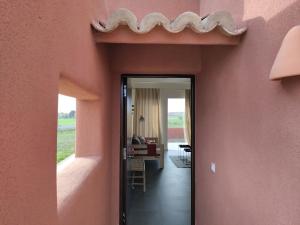 雷阿尔城La Cobija Apartamentos - Solo Adultos的粉红色墙壁房子的走廊