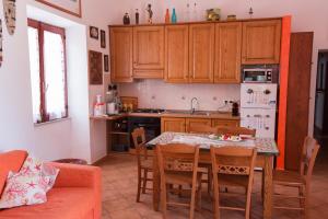 利帕里Il Pesce e il Geco的一个带桌椅的厨房和一间带木制橱柜的厨房